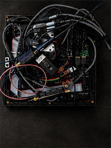 The inside of the pack’s back panel: circuit boards, radio hardware, antennas and braided cable runs packed onto a black frame behind the LED matrix.